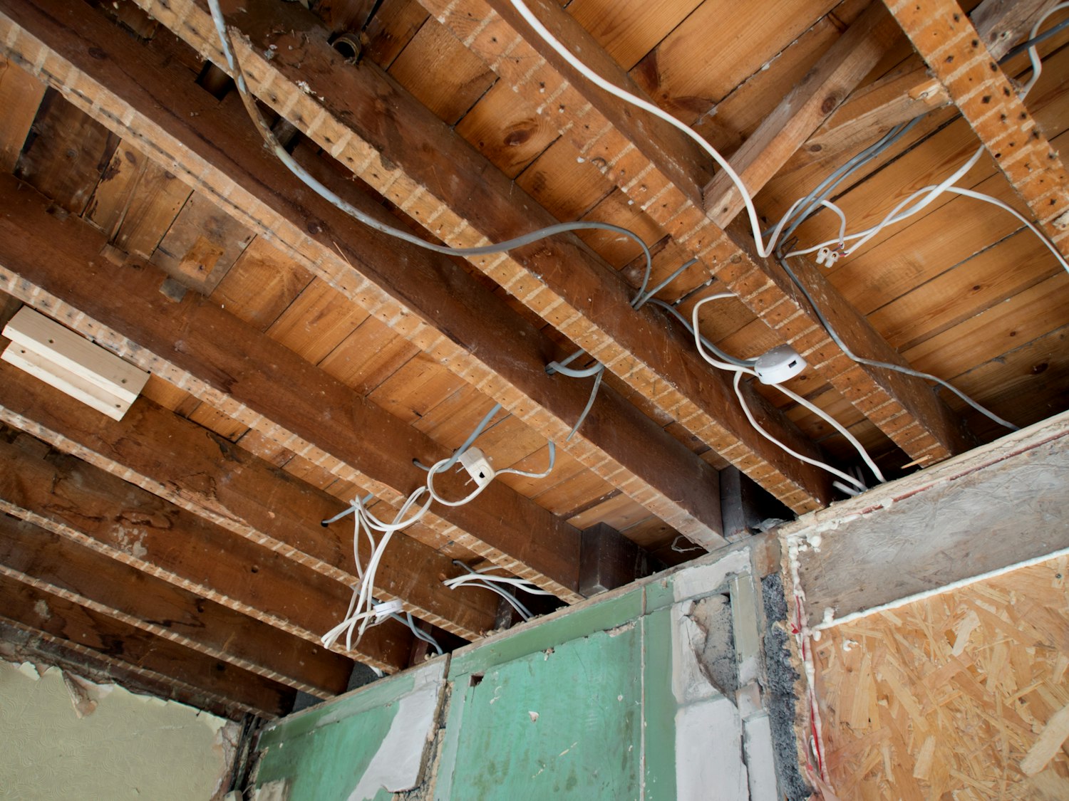 Exposed ceiling joists with electrical wiring during renovation
